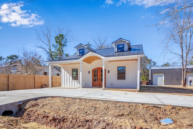 modern farmhouse featuring a garage, an outbuilding, and french doors