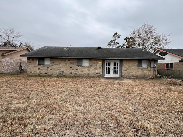 rear view of property featuring a lawn and french doors