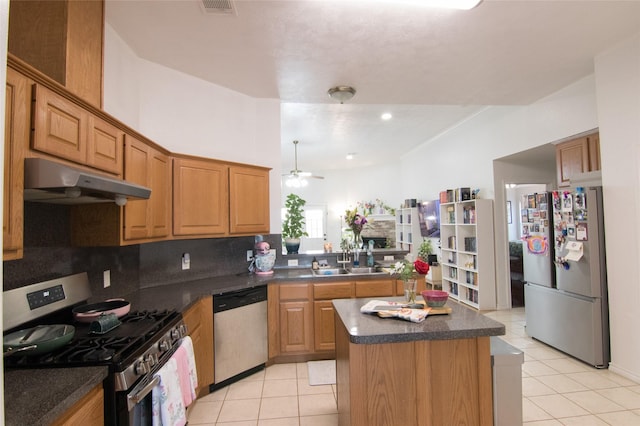 kitchen with light tile patterned flooring, stainless steel appliances, a center island, and sink