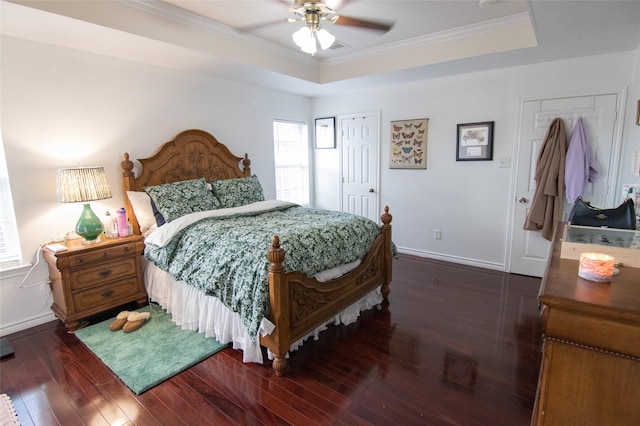 bedroom with dark wood-type flooring, ceiling fan, crown molding, and a raised ceiling