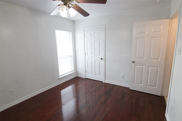 unfurnished bedroom with multiple windows, dark hardwood / wood-style flooring, and ceiling fan