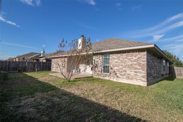 rear view of property with a yard and a patio area