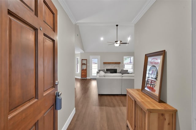 entrance foyer featuring crown molding, light wood-type flooring, ceiling fan, and a fireplace