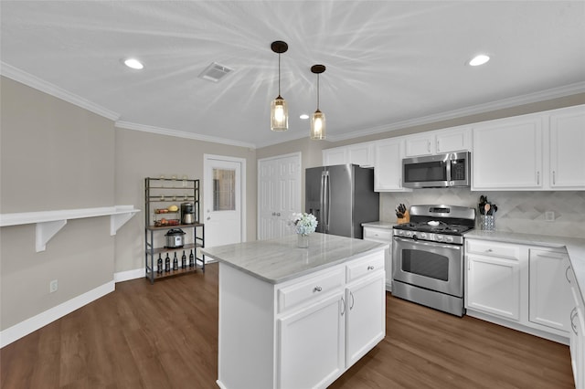 kitchen featuring white cabinetry, decorative light fixtures, appliances with stainless steel finishes, a kitchen island, and light stone countertops