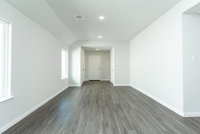 empty room with vaulted ceiling and dark wood-type flooring