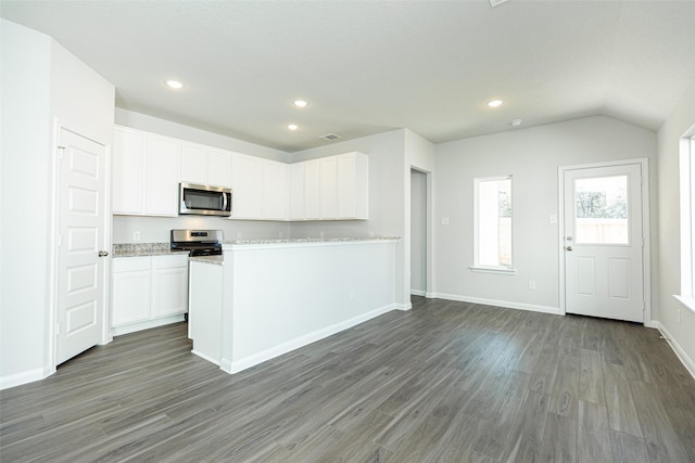 kitchen featuring lofted ceiling, white cabinets, dark hardwood / wood-style flooring, light stone counters, and stainless steel appliances