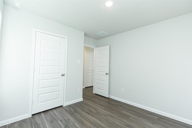 unfurnished bedroom featuring dark hardwood / wood-style flooring