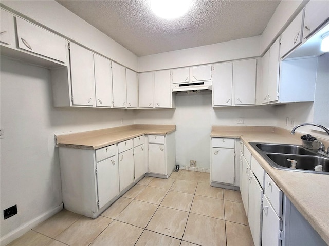 kitchen featuring white cabinetry, sink, and a textured ceiling