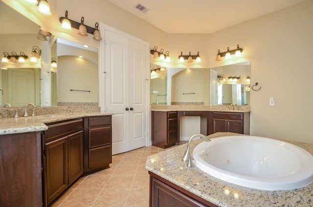 bathroom with tile patterned flooring, vanity, and a bathing tub