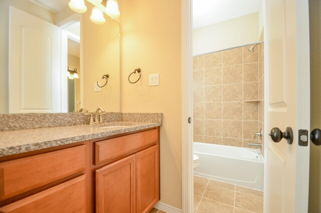 full bathroom with tiled shower / bath combo, vanity, tile patterned flooring, and toilet