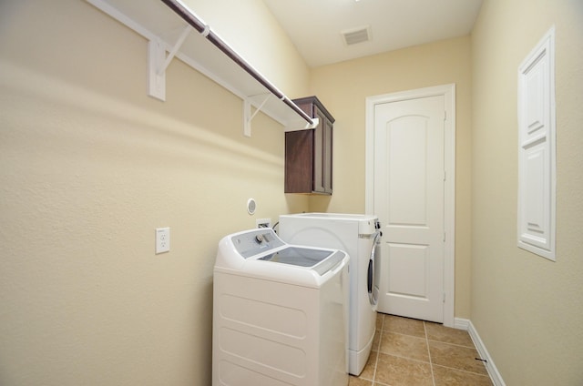 washroom with cabinets, light tile patterned flooring, and washer and dryer