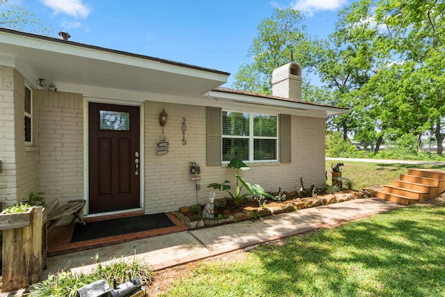 entrance to property with a lawn