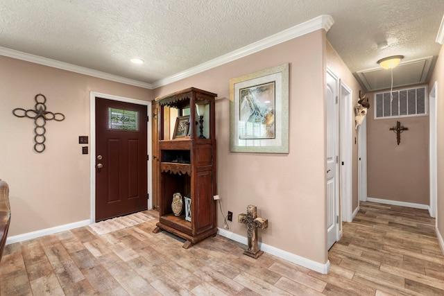 entryway with crown molding, light hardwood / wood-style flooring, and a textured ceiling