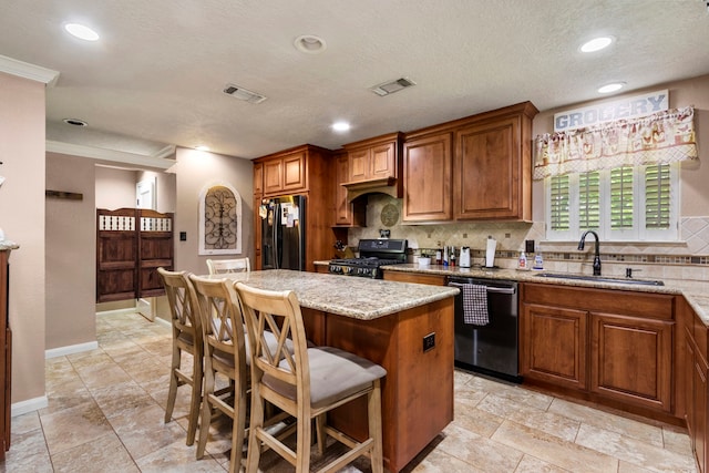 kitchen featuring dishwashing machine, sink, range, a center island, and black fridge