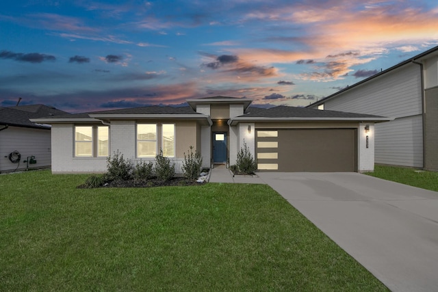 view of front of house with a garage and a yard