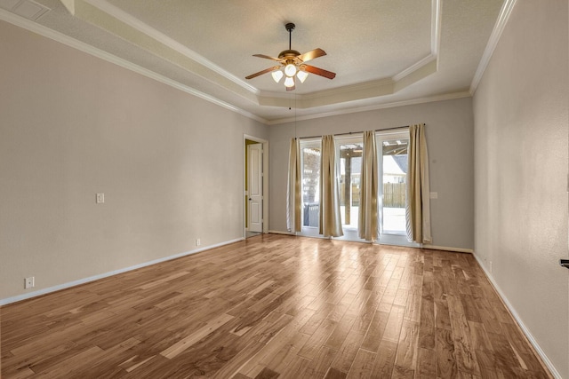 spare room with hardwood / wood-style floors, crown molding, a raised ceiling, and ceiling fan