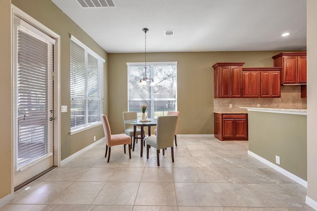 tiled dining space featuring an inviting chandelier