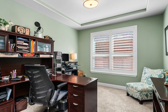 home office featuring light colored carpet and a raised ceiling