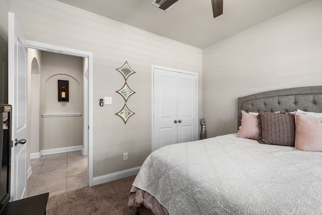 bedroom with light tile patterned floors, ceiling fan, and a closet