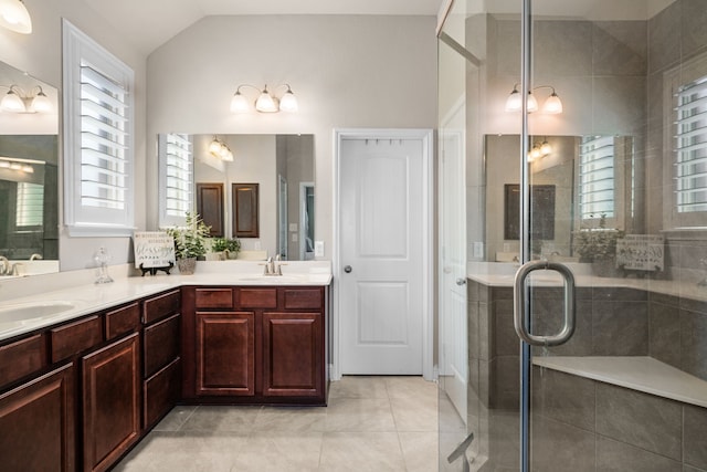 bathroom with tile patterned flooring, vanity, vaulted ceiling, and a shower with door