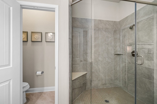 bathroom featuring walk in shower, tile patterned floors, and toilet