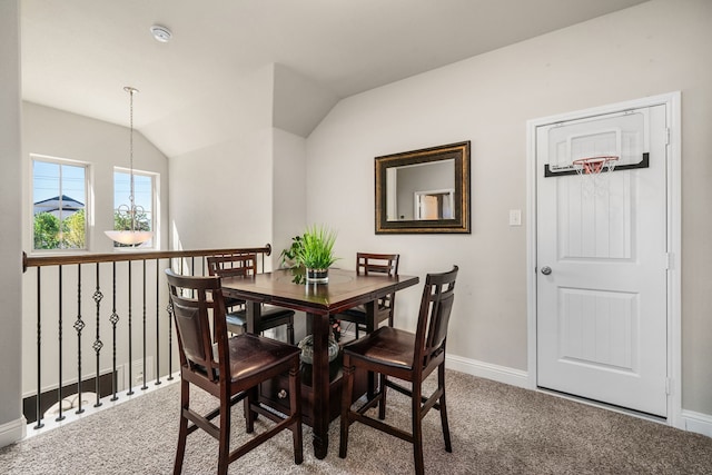 dining area with vaulted ceiling and carpet