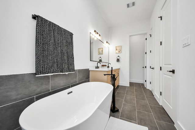 bathroom featuring a washtub, vanity, and tile patterned floors