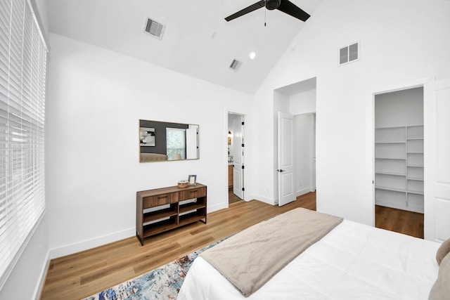 bedroom with ensuite bath, a walk in closet, high vaulted ceiling, a closet, and ceiling fan