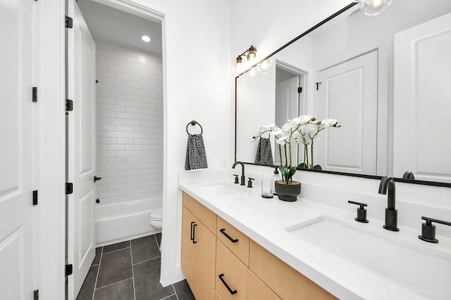 full bathroom with tiled shower / bath, tile patterned floors, toilet, and vanity