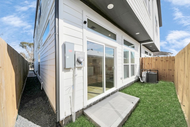 view of side of home with cooling unit and a lawn