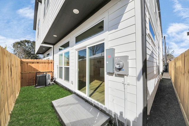 view of side of property with a yard and central air condition unit