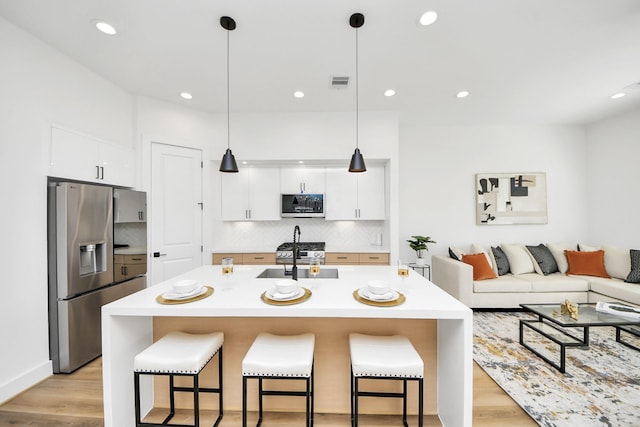 kitchen with white cabinetry, stainless steel fridge with ice dispenser, hanging light fixtures, and a breakfast bar