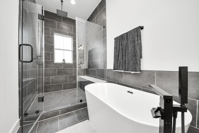 bathroom with tile patterned floors and shower with separate bathtub