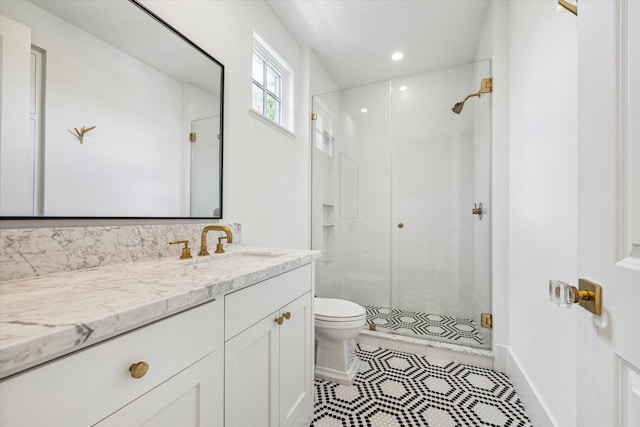 bathroom featuring vanity, an enclosed shower, and toilet