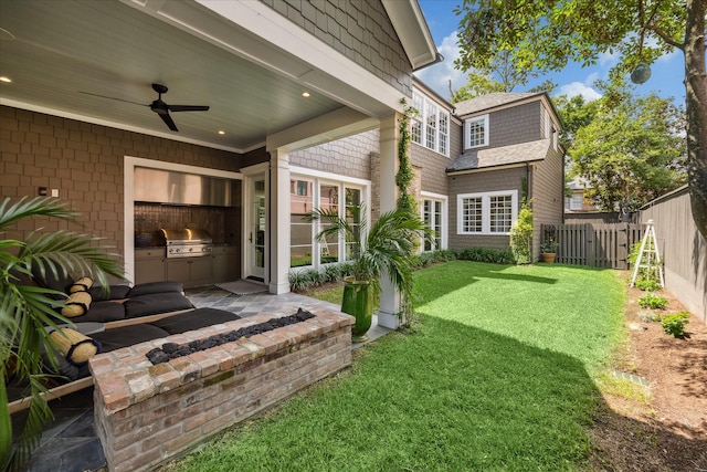 view of yard featuring ceiling fan and an outdoor kitchen