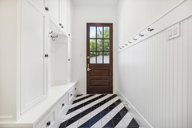 mudroom with dark tile patterned flooring