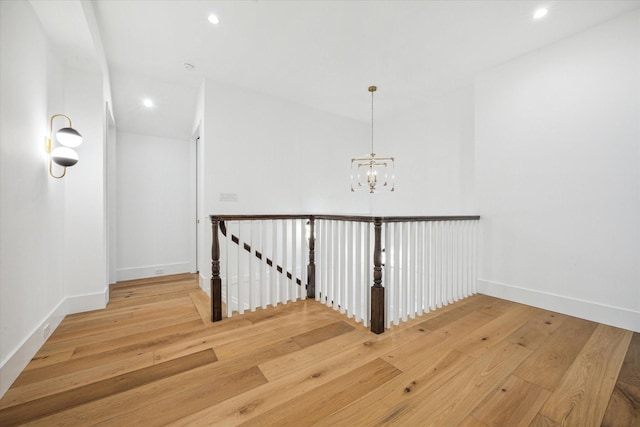 hall with an inviting chandelier and light wood-type flooring