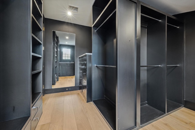 walk in closet with hardwood / wood-style flooring