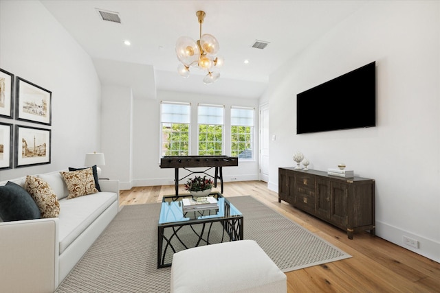 living room with an inviting chandelier and light hardwood / wood-style floors