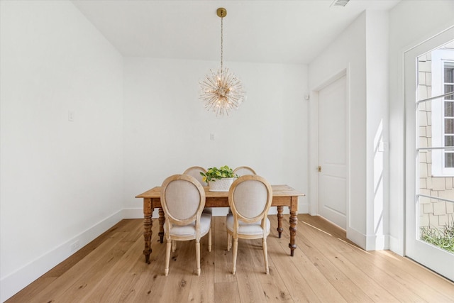 dining room featuring light wood-type flooring and a notable chandelier