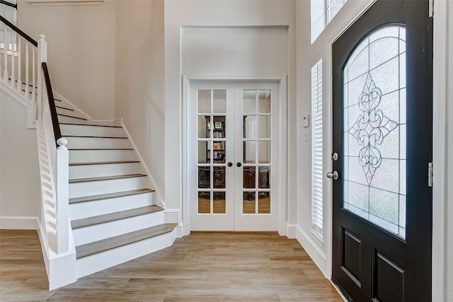 entrance foyer with light hardwood / wood-style floors and french doors