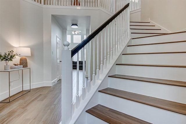 staircase with a towering ceiling and hardwood / wood-style floors