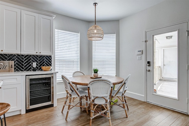 dining space featuring light hardwood / wood-style floors and beverage cooler