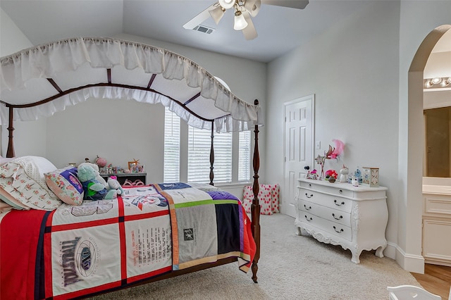 carpeted bedroom with lofted ceiling, ceiling fan, and ensuite bath