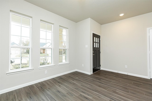 unfurnished room with dark wood-type flooring