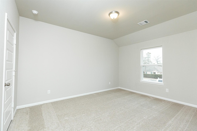 carpeted empty room with lofted ceiling