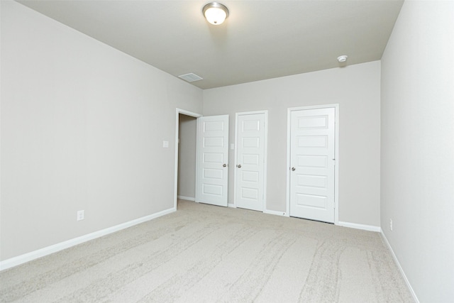 unfurnished bedroom featuring light carpet