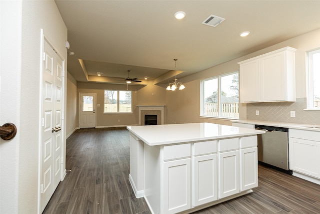 kitchen featuring dark wood-type flooring, stainless steel dishwasher, a center island, and white cabinets