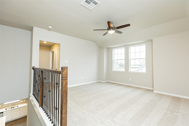 empty room with lofted ceiling, light carpet, and ceiling fan