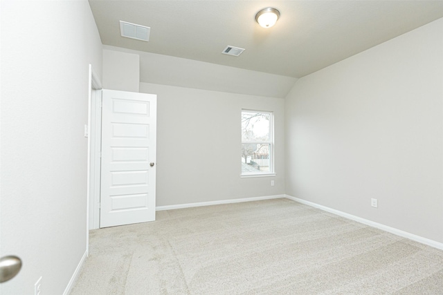 carpeted empty room with lofted ceiling